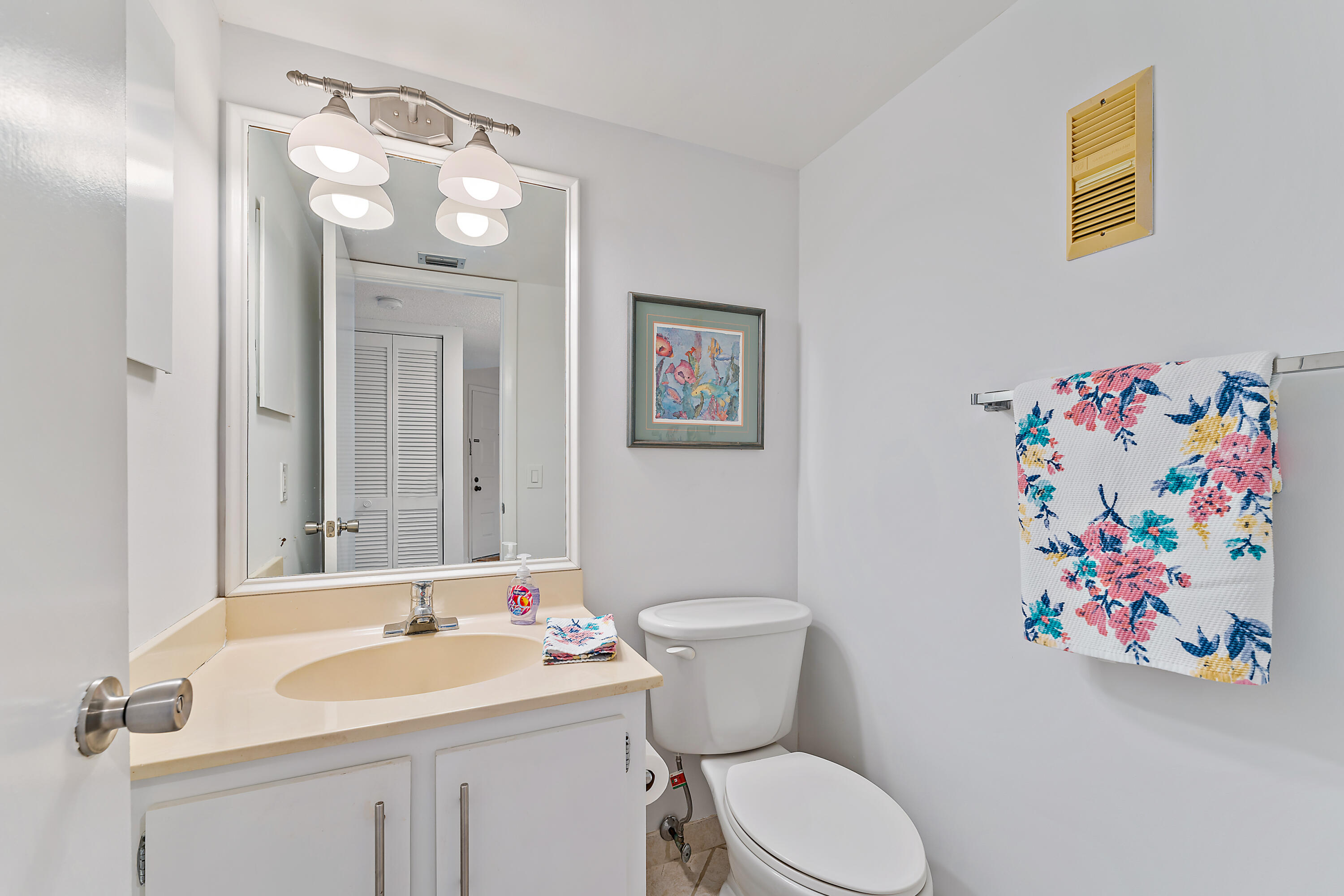 1605 Highway 1, Unit F305 Jupiter, FL 33477 - Photo 21 of 31 a bathroom with a sink a toilet and a mirror