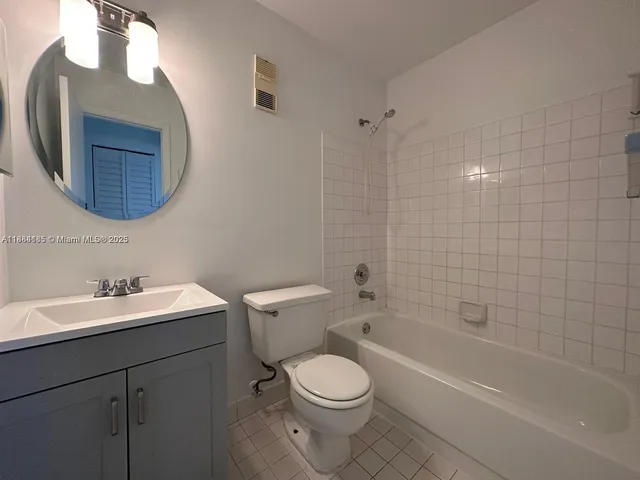 a bathroom with a toilet a sink a mirror and bathtub