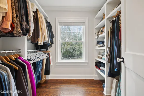 a view of walk in closet with clothes and shoes