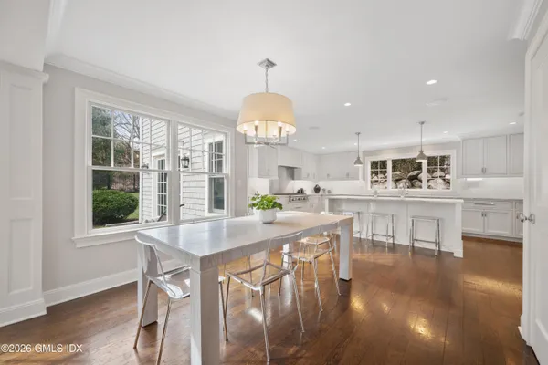 a kitchen with stainless steel appliances granite countertop a stove and a dining table with wooden floor