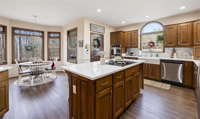 a kitchen with stainless steel appliances a dining table and chairs