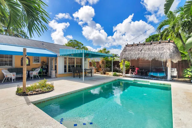 a view of a house with swimming pool and sitting area