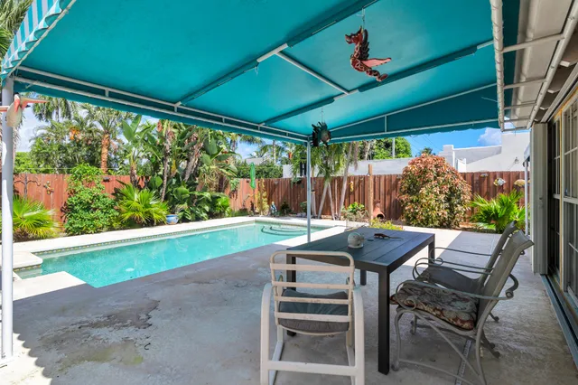 a view of a patio with a table chairs and a backyard