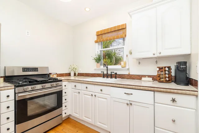 a kitchen with white cabinets and appliances