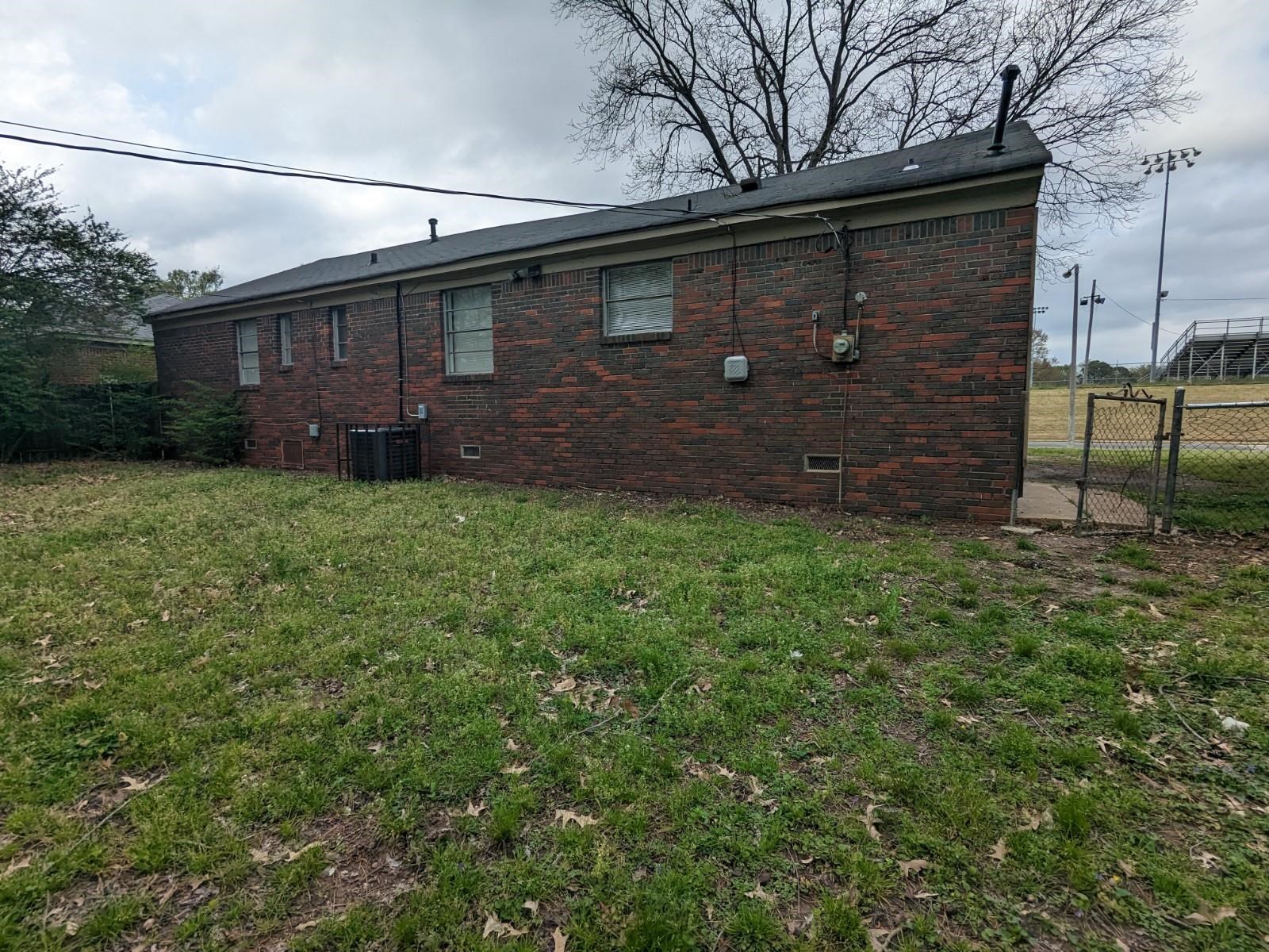 3063 Christine Road Memphis, TN 38118 - Photo 20 of 20 Back of house with crawl space, brick siding, a yard, and fence