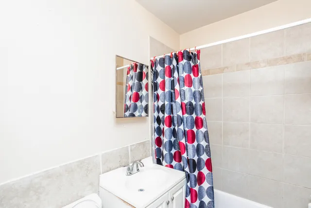a bathroom with a shower curtain and sink