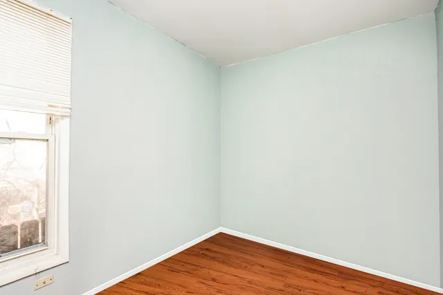 a view of a small space with wooden floor and a window