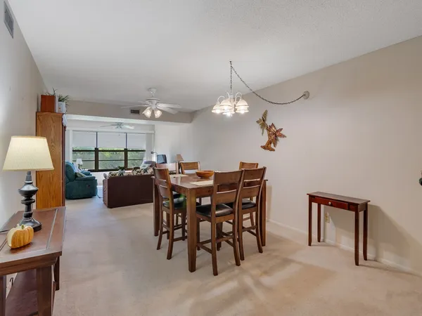 a view of a dining room and kitchen with furniture and a chandelier