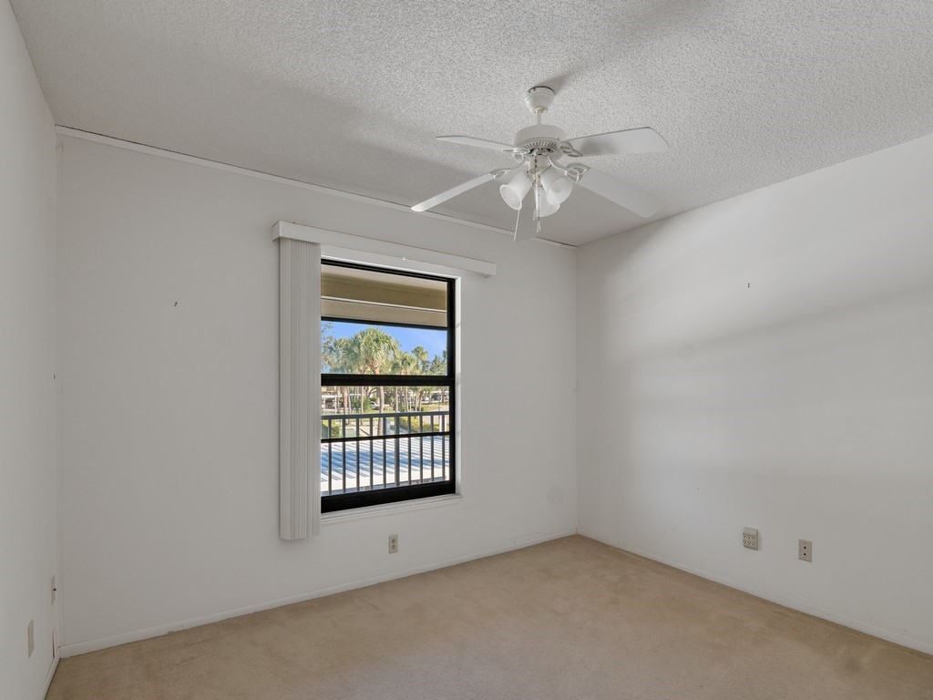 27 Plantation Drive, Unit 202 Vero Beach, FL 32966 - Photo 12 of 30 an empty room with windows and fan