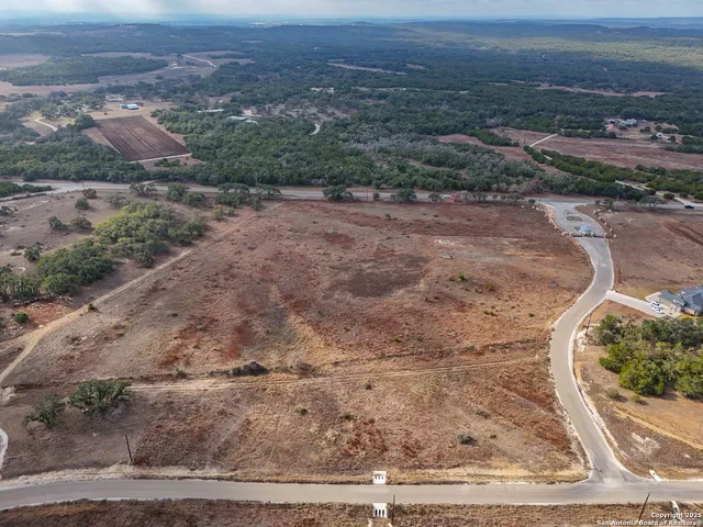a view of a dry yard with wooden fence