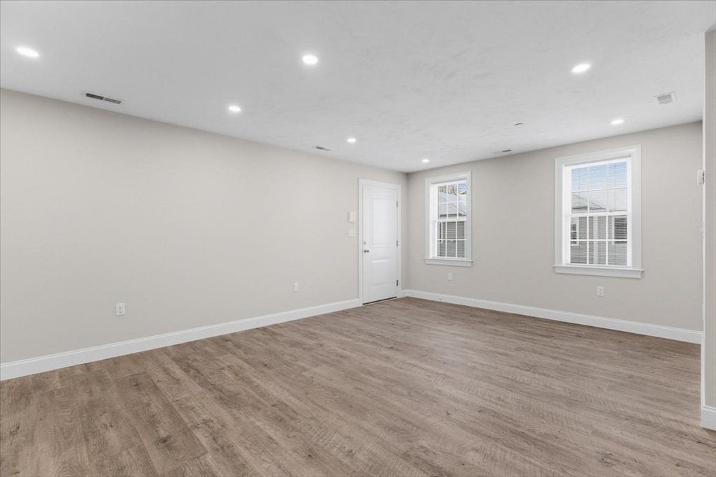 202 Central Street, Unit I Avon, MA 02322 - Photo 11 of 19 a view of empty room with wooden floor and fan
