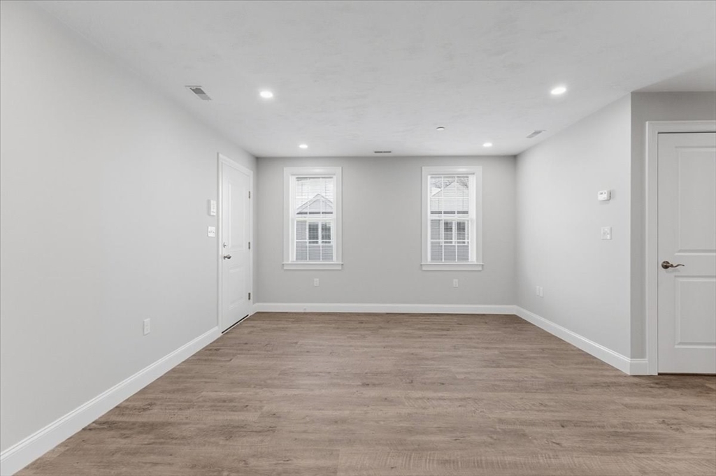 202 Central Street, Unit I Avon, MA 02322 - Photo 12 of 19 an empty room with wooden floor and windows