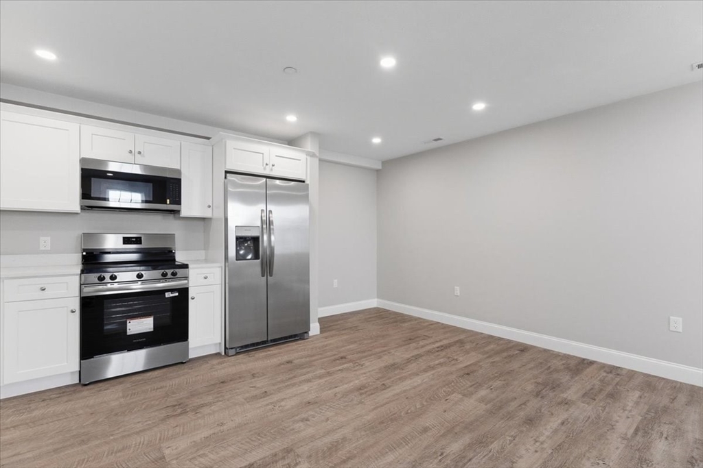 202 Central Street, Unit I Avon, MA 02322 - Photo 2 of 19 a kitchen with stainless steel appliances a refrigerator and a stove top oven