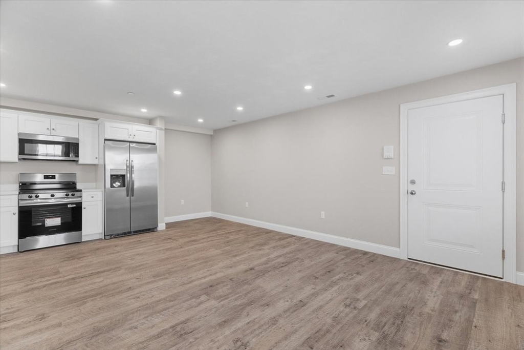 202 Central Street, Unit I Avon, MA 02322 - Photo 5 of 19 a view of a kitchen with a sink and a refrigerator