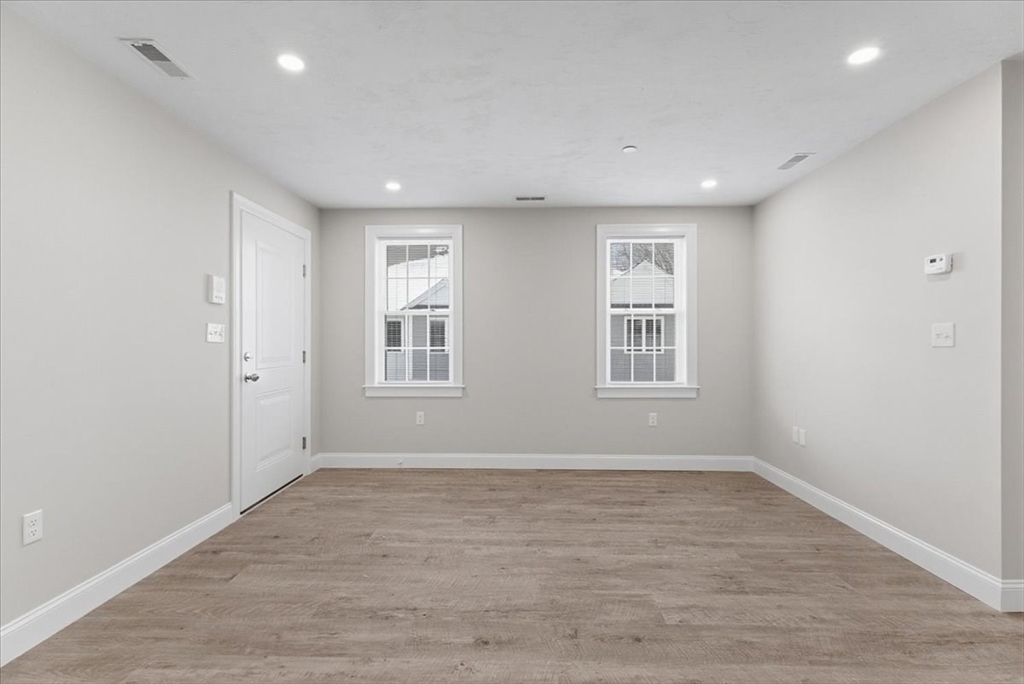 202 Central Street, Unit I Avon, MA 02322 - Photo 9 of 19 a view of an empty room with wooden floor and a window