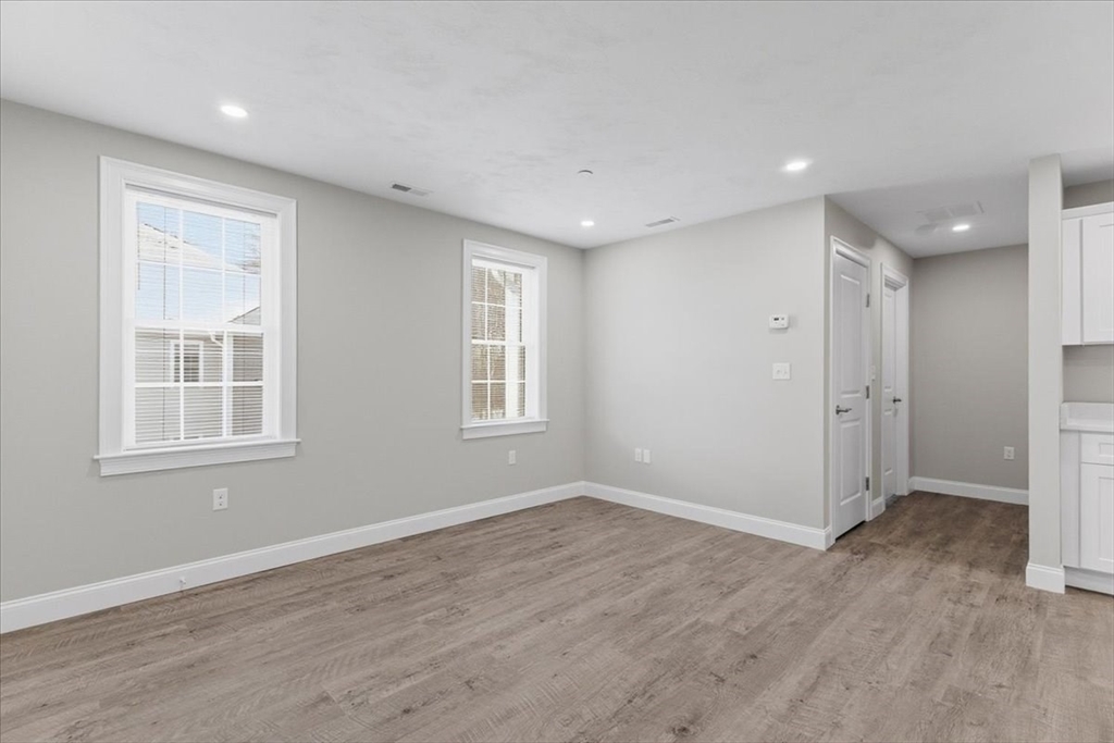 202 Central Street, Unit I Avon, MA 02322 - Photo 10 of 19 an empty room with wooden floor and windows