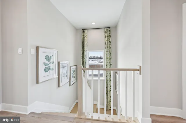 a view of a hallway with wooden floor and entryway