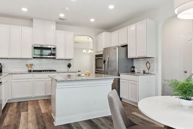 a kitchen with refrigerator a sink and white cabinets