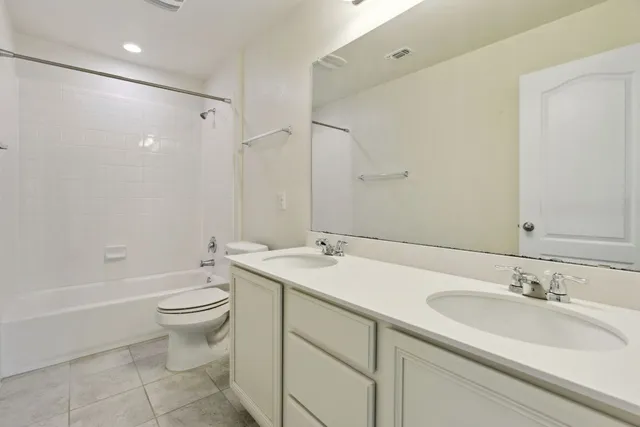 a bathroom with a sink double vanity granite toilet and a bathtub