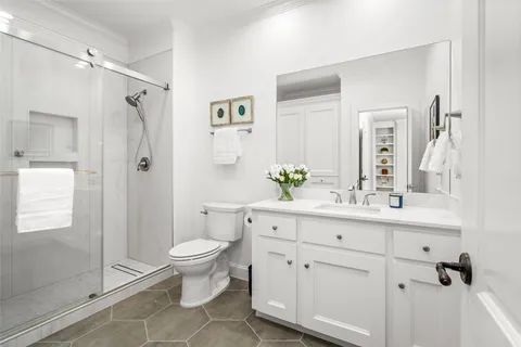 a bathroom with a sink a toilet and shower