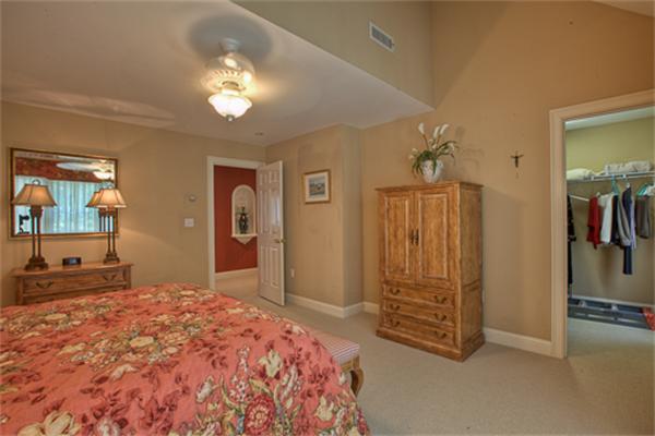 4 Coppersmyth Way, Unit 4 Lexington, MA 02421 - Photo 18 of 28 a bedroom with a large bed and a chandelier