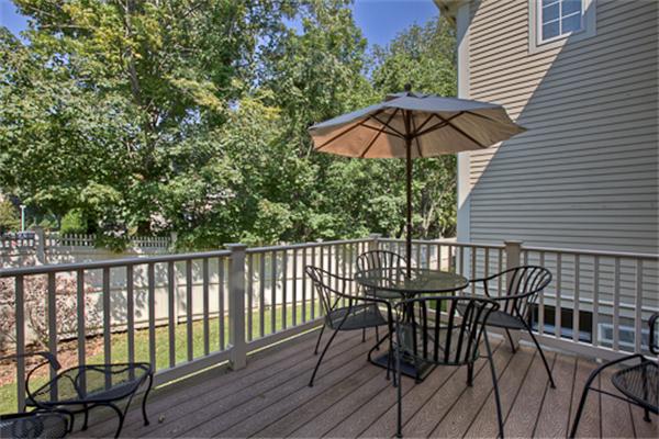 4 Coppersmyth Way, Unit 4 Lexington, MA 02421 - Photo 25 of 28 a view of a chair and table on the deck