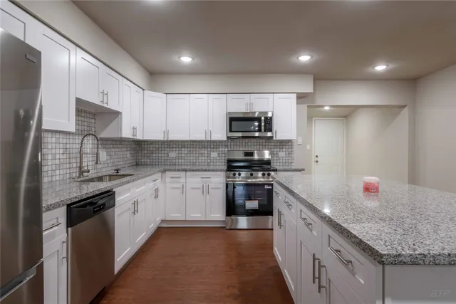 a kitchen with stainless steel appliances granite countertop a sink stove and refrigerator
