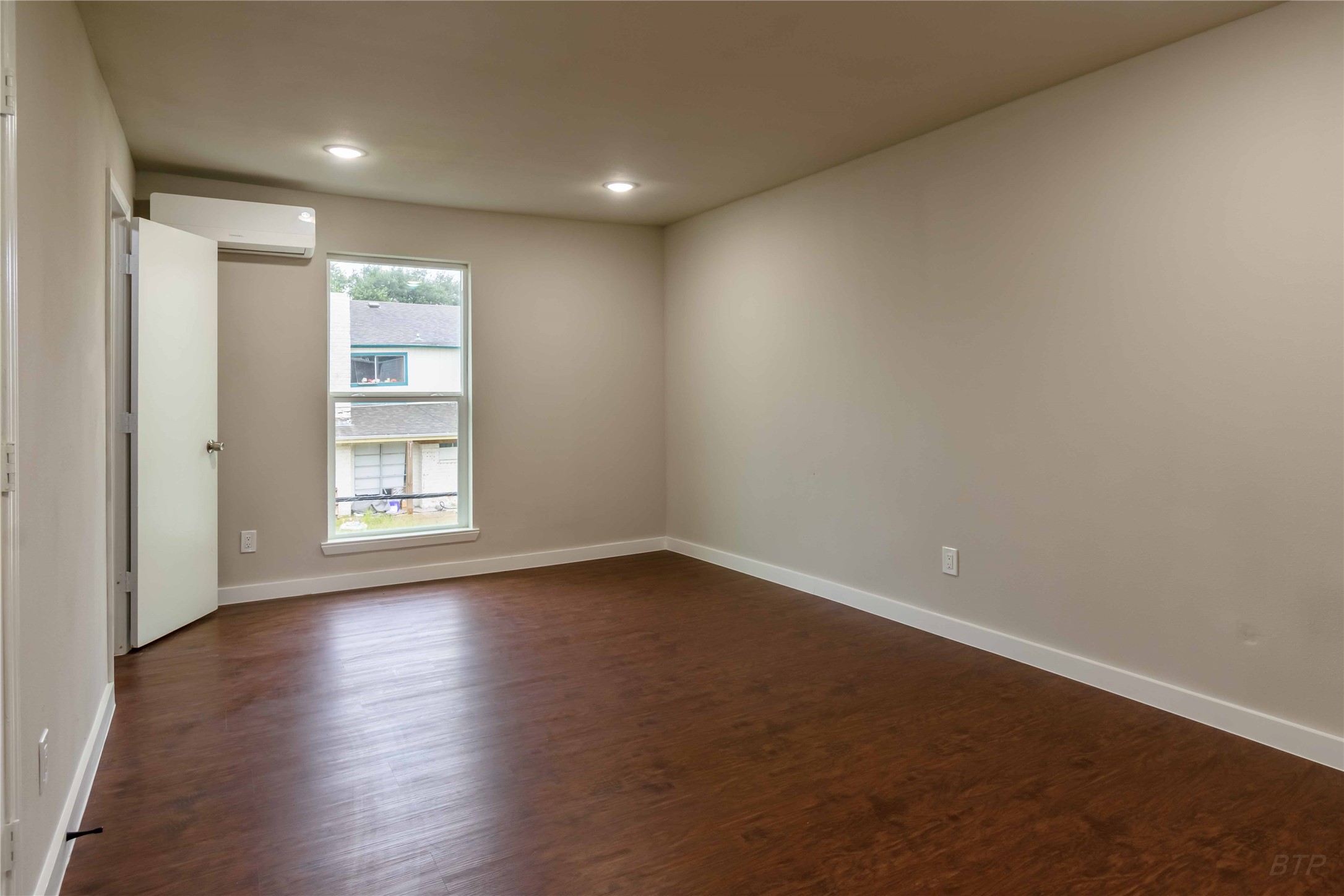 11933 Beechnut Street Houston, TX 77072 - Photo 8 of 9 an empty room with wooden floor and windows
