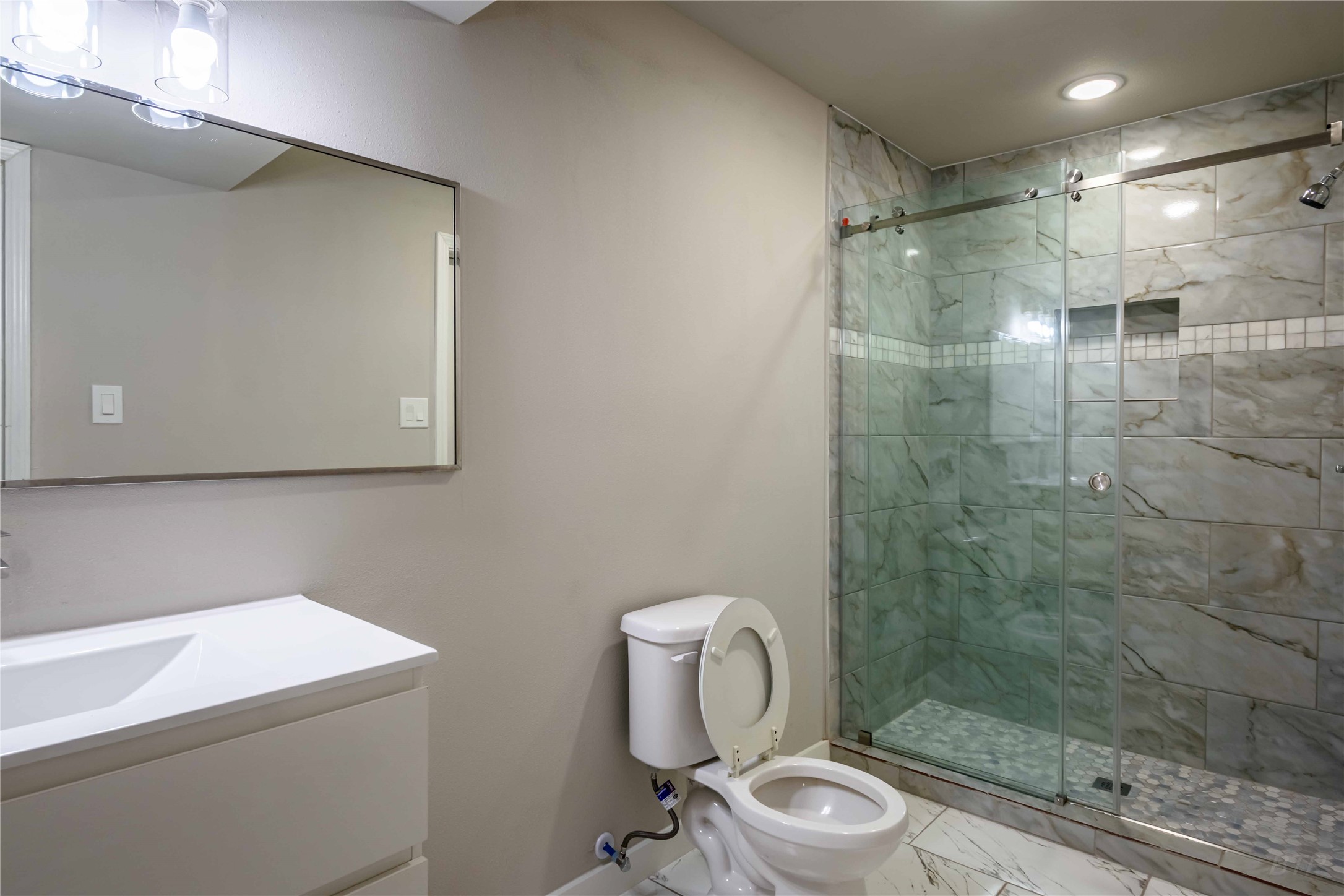 11933 Beechnut Street Houston, TX 77072 - Photo 9 of 9 a bathroom with a toilet sink vanity and shower