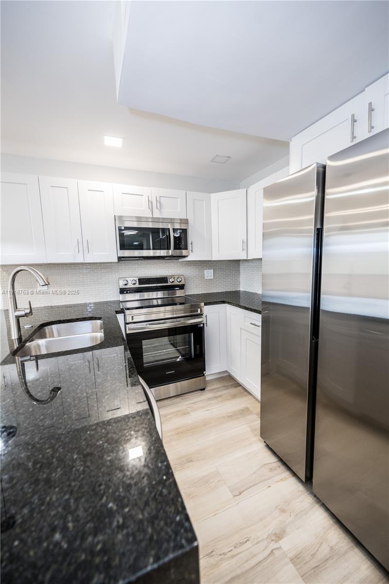 755 Dotterel Road, Unit 1301 Delray Beach, FL 33444 - Photo 3 of 15 a kitchen with kitchen island a counter top space cabinets and stainless steel appliances