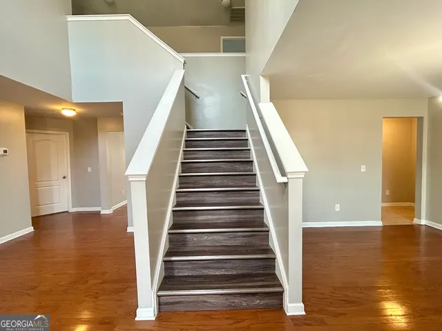 a view of a room with wooden floor and ceiling fan