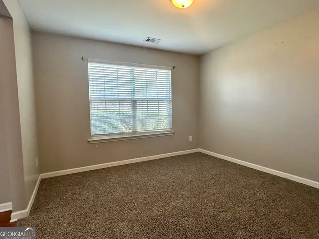 an empty room with closet and mirror