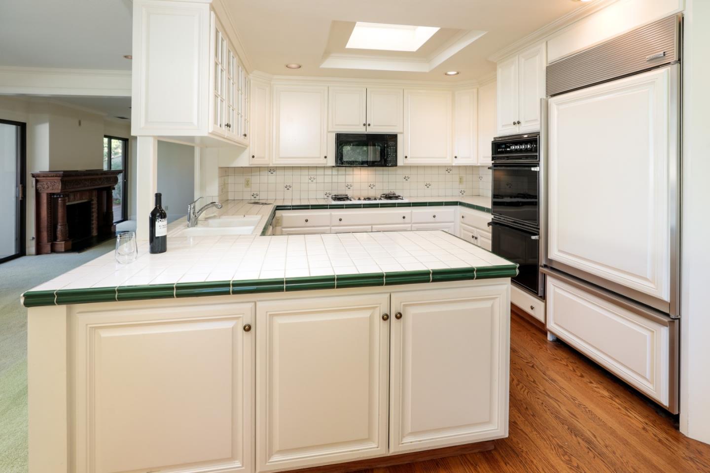 47 Bay Tree Lane Los Altos, CA 94022 - Photo 4 of 34 a kitchen with granite countertop white cabinets and stainless steel appliances
