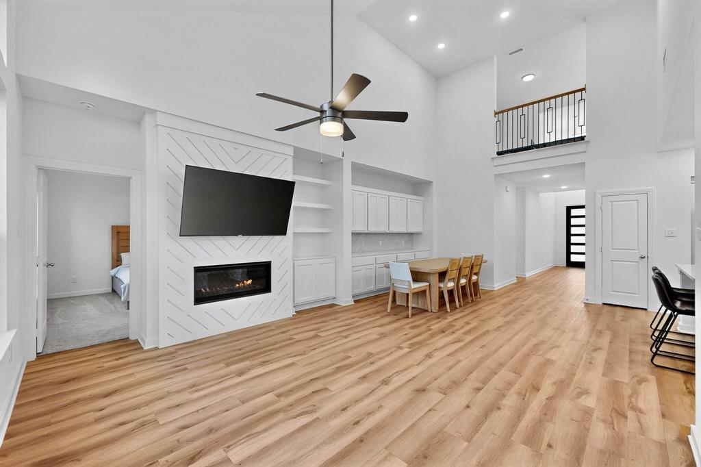 2017 Fall Crk Cove Mesquite, TX 75181 - Photo 12 of 40 Living room with recessed lighting, high vaulted ceiling, light wood finished floors, a large fireplace, and ceiling fan