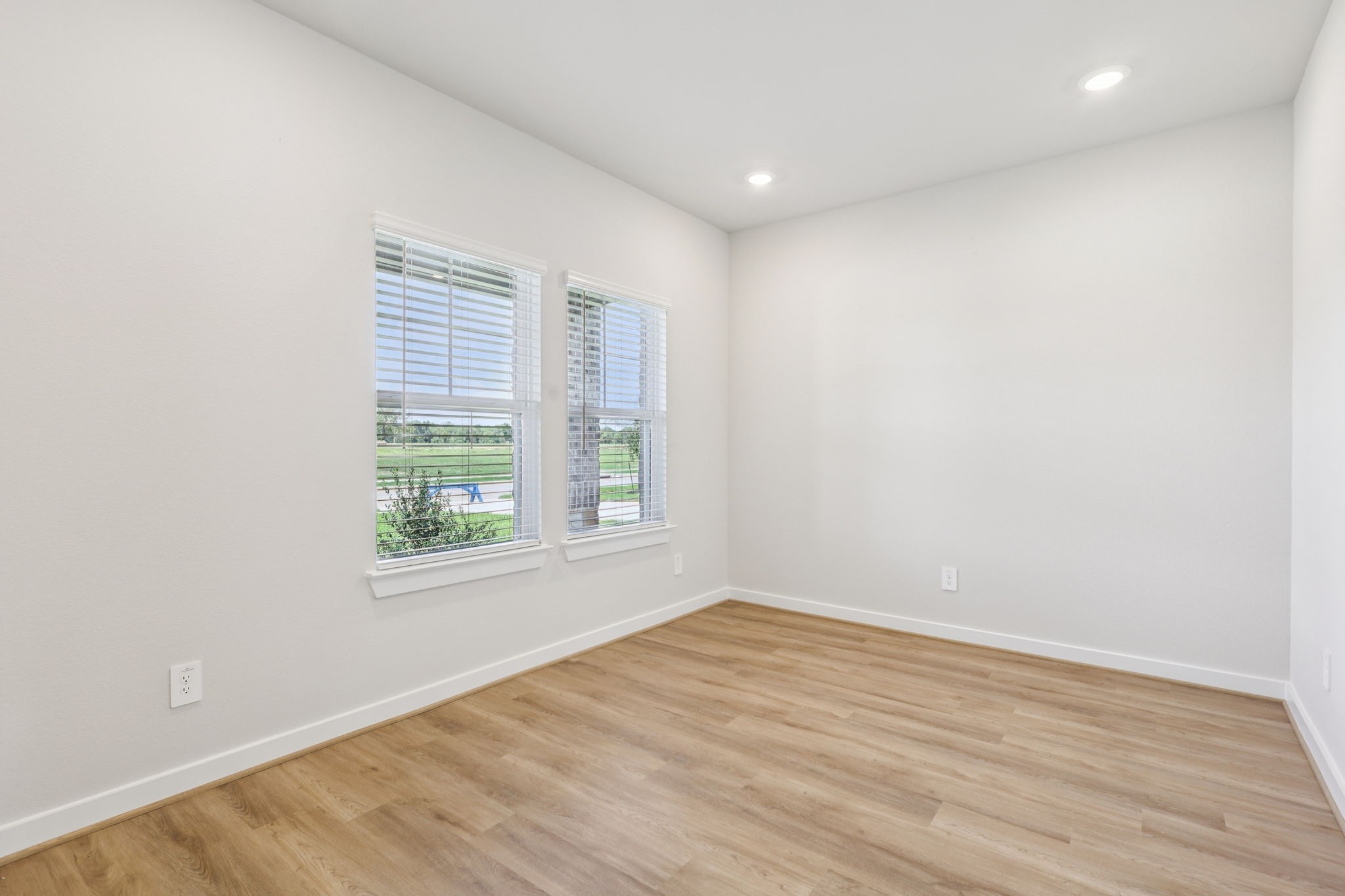 5223 Kingdom Heights Boulevard Rosenberg, TX 77471 - Photo 4 of 41 an empty room with wooden floor and windows