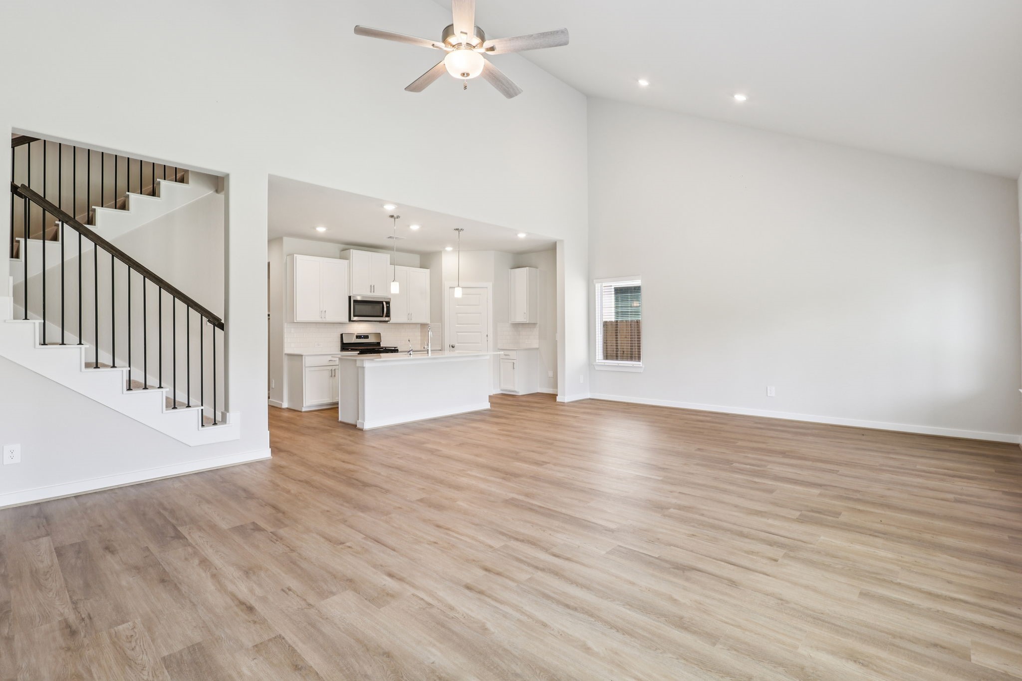 5223 Kingdom Heights Boulevard Rosenberg, TX 77471 - Photo 10 of 41 a view of a kitchen and an empty room with wooden floor