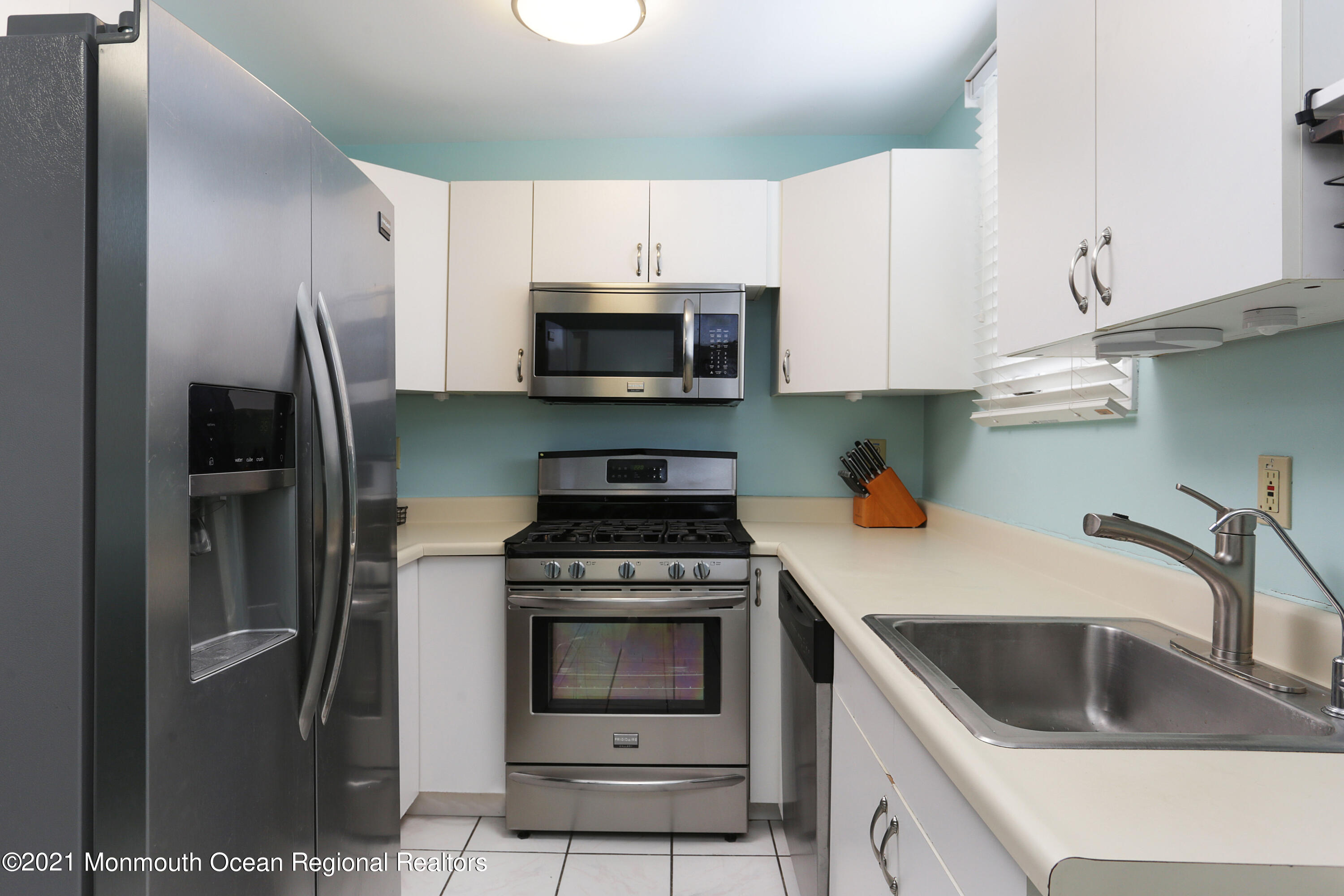 100 1st Street, Unit 11 Keyport, NJ 07735 - Photo 9 of 29 a kitchen with white cabinets and stainless steel appliances