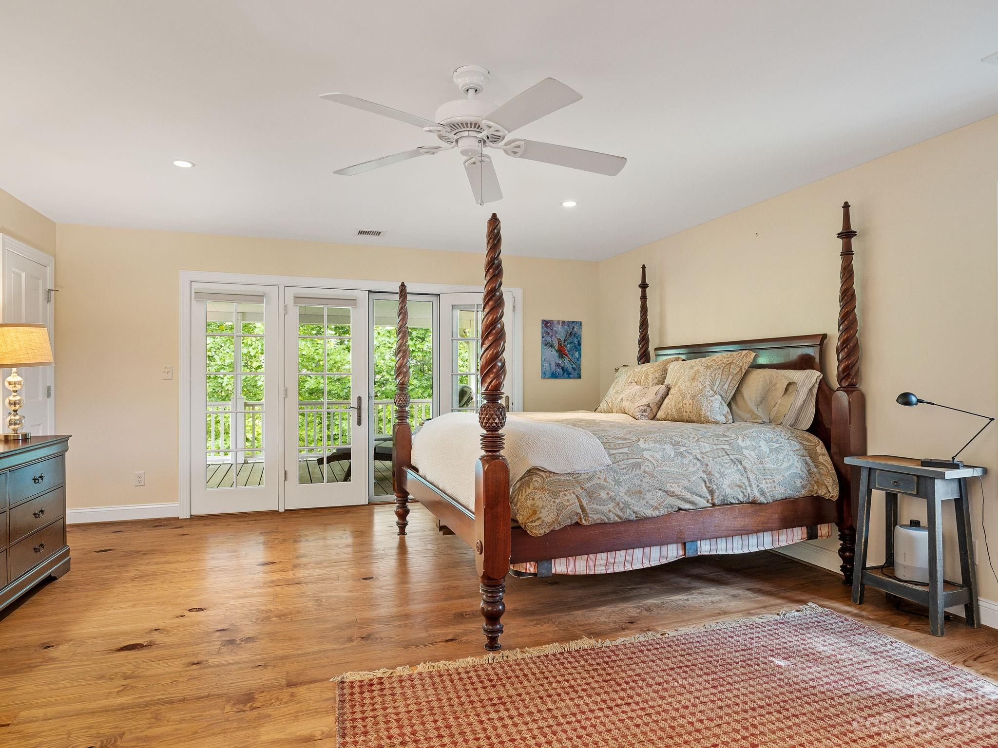 795 Golden Road Tryon, NC 28782 - Photo 17 of 32 a bedroom with a large bed and a chandelier