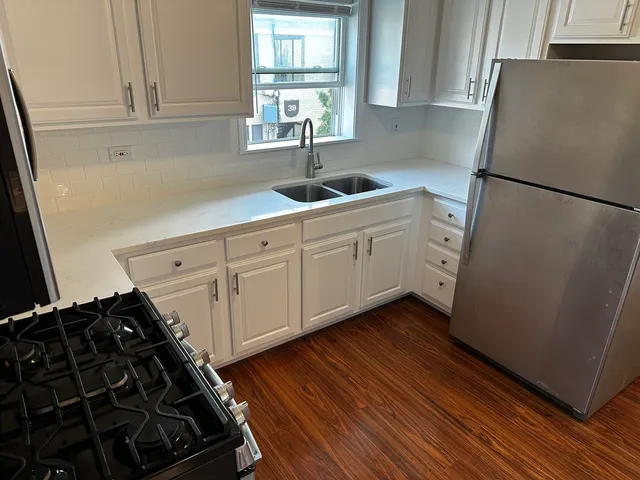 a kitchen with sink window and refrigerator