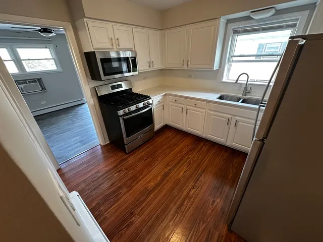 a kitchen with a sink a microwave a stove and refrigerator