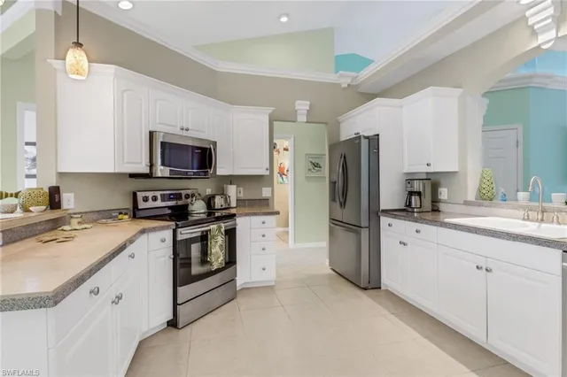 a kitchen with refrigerator a sink a stove a microwave and cabinets