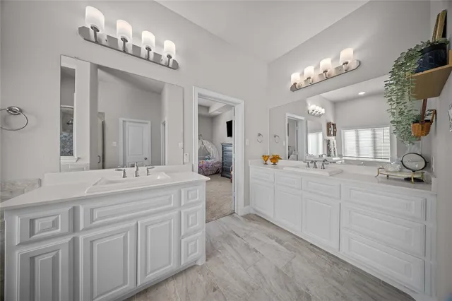 a spacious bathroom with a double vanity sink and a mirror