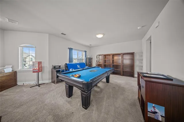 a room with furniture pool table and window