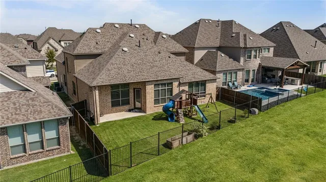 a view of a house with floor to ceiling windows and wooden fence