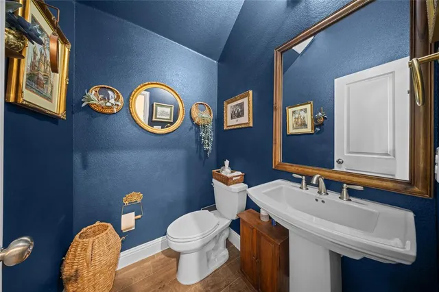 a bathroom with a toilet sink vanity and mirror