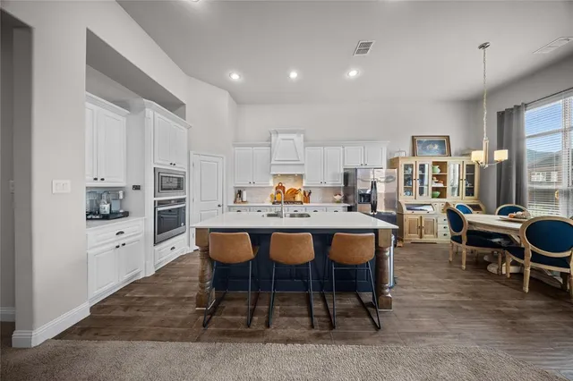 a large kitchen with a table and chairs in it