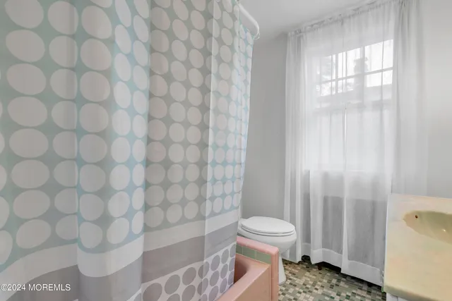 a spacious bedroom with a bed and a chandelier