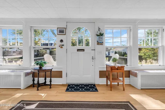 a living room with wooden floor and a large window