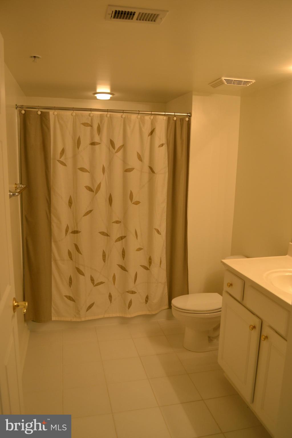 12246 Roundwood Road, Unit 405 Lutherville-Timonium, MD 21093 - Photo 12 of 16 a bathroom with a shower curtain and a sink