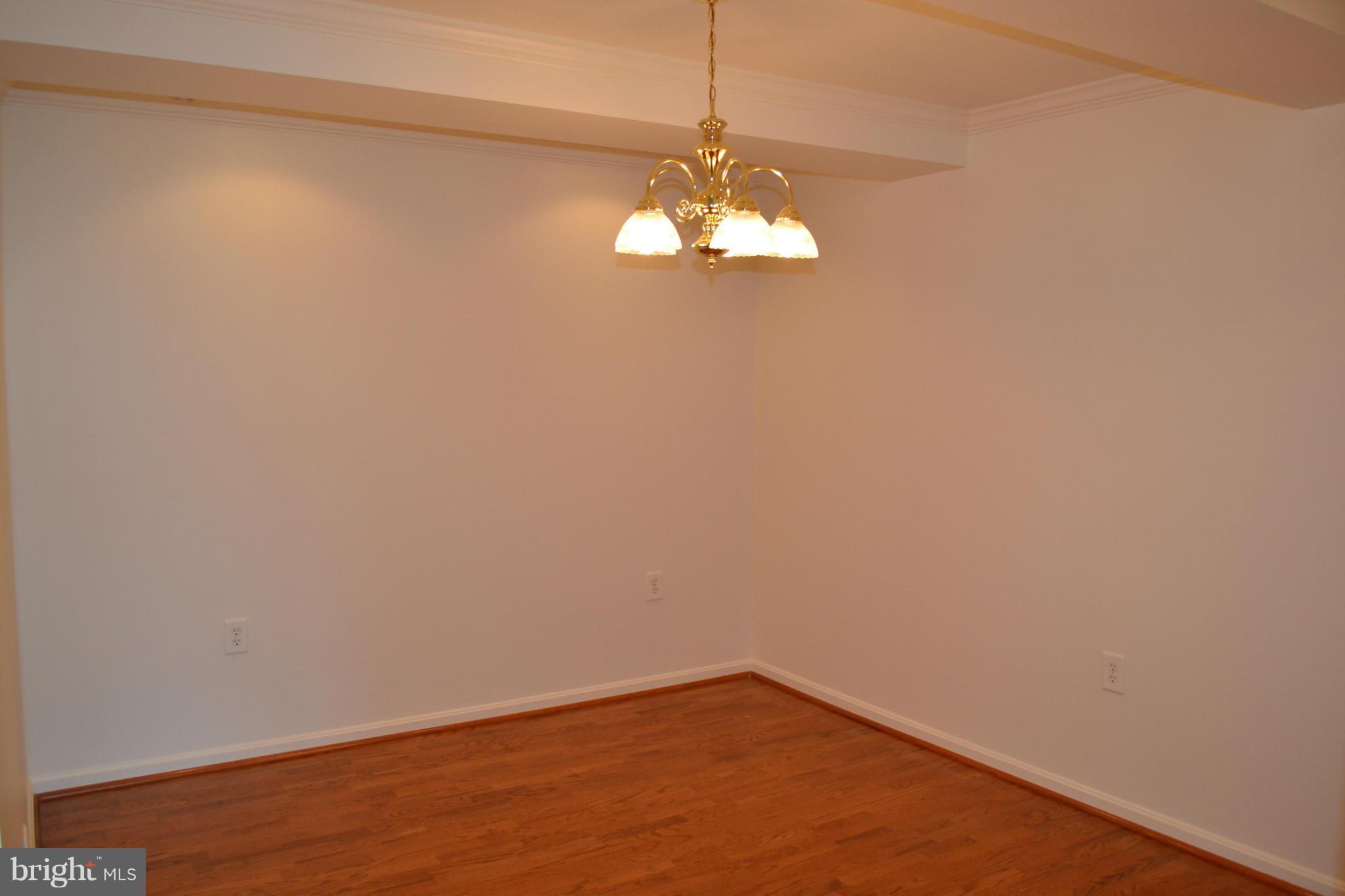 12246 Roundwood Road, Unit 405 Lutherville-Timonium, MD 21093 - Photo 8 of 16 a view of a big room with wooden floor and chandelier